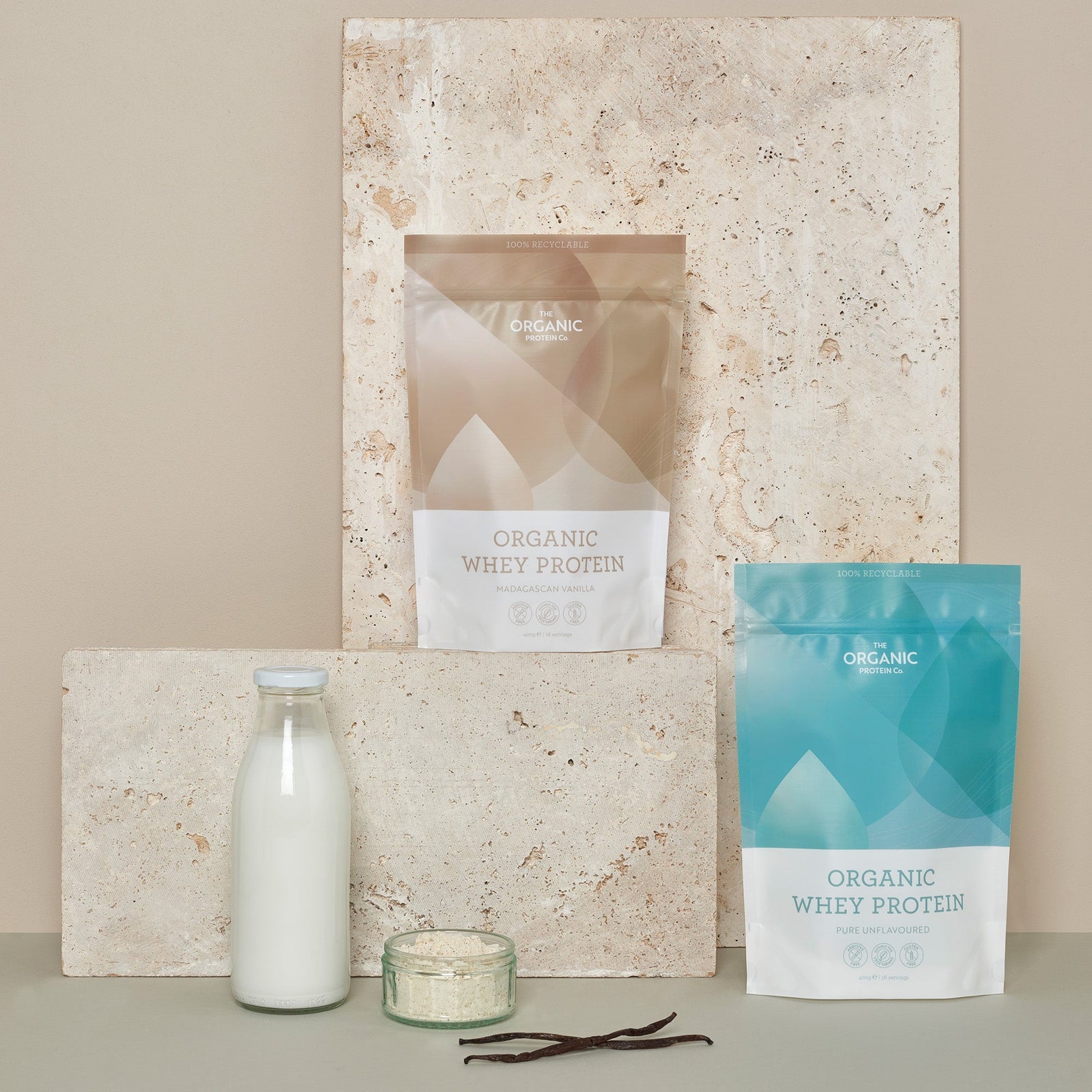 Two packets of organic whey protein powder with milk and vanilla pods